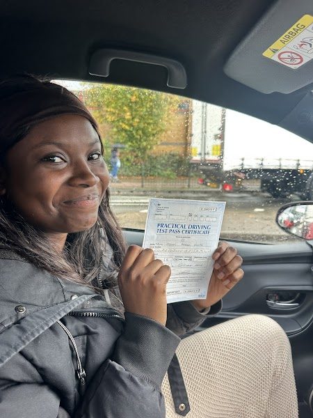 A delighted learner in the driving school car after passing her practical test