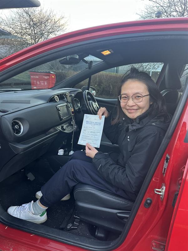 New driver holding pass certificate inside the car